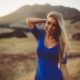 Woman in a blue dress posing in the desert for a picture.