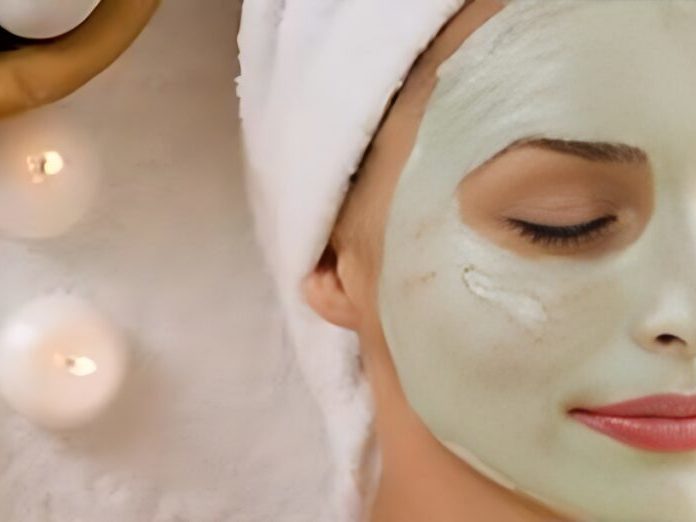 Woman with green mask on her face getting a facial.