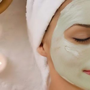 Woman with a green facial mask on at Deja Vu Med Spa and Salon.