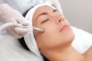 Woman on bed receiving a Microdermabrasion service from Déjà Vu Med Spa and Salon