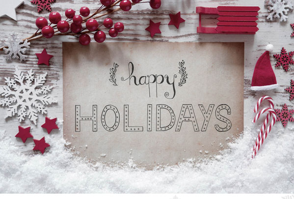 Happy Holiday on faded paper against a wood table.