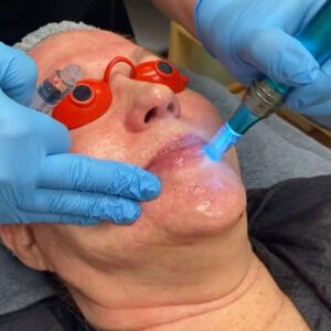 Woman laying on a bed receiving a facial.