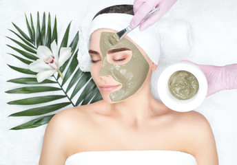 Woman receiving a facial with green mask.