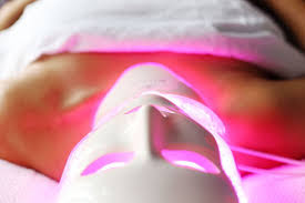 Lady on bed receiving Deep Cleansing Facial with Red Light Therapy and High Frequency.