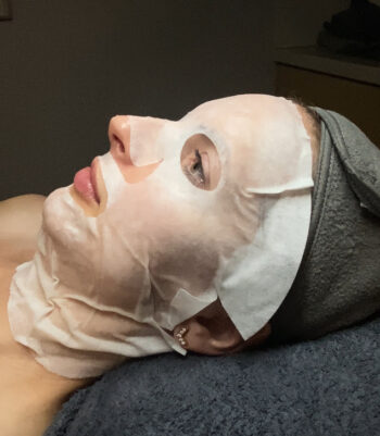 Woman on table with white mask on.